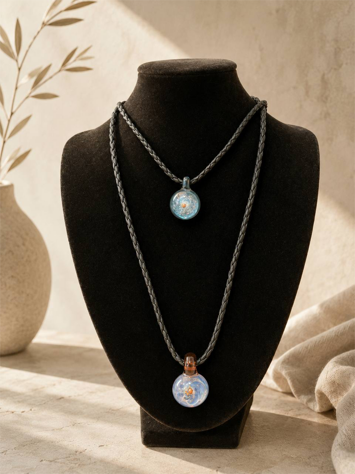 two pendants on display bust